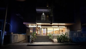 Entrada de hotel con un cartel que dice 'HOTEL DASYA' y una escalera que conduce a la entrada.