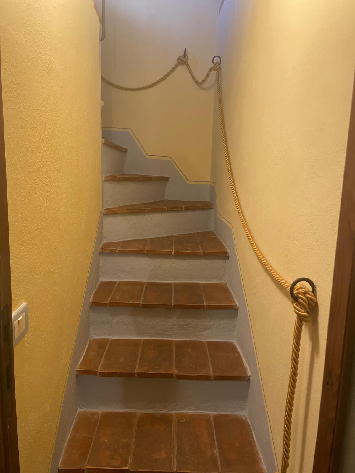 Un escalier surmonté d’une barrière faite de cordes.