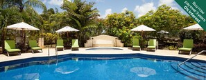 A swimming pool with lounge chairs and umbrellas, surrounded by lush greenery. - Charming 3-bedroom townhome with AC, fitness room in Mullins (Mullins)