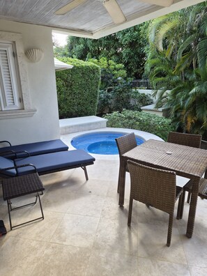 A covered outdoor area with a pool, lounge chairs, and a table. - Charming 3-bedroom townhome with AC, fitness room in Mullins (Mullins)