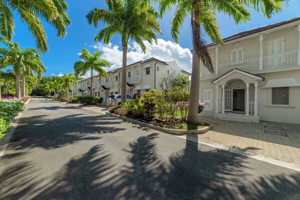 A street lined with palm trees and a row of white buildings with balconies. - Charming 3-bedroom townhome with AC, fitness room in Mullins (Mullins)