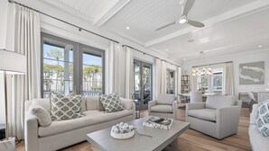 A spacious living room with a large sofa, a coffee table, and a dining area. - Elevated Vacation Living• Fairmont Inspiration by the Bay (Miramar Beach)
