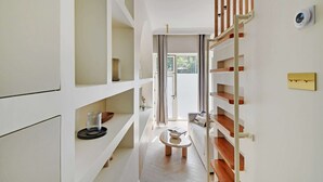 A modern interior with a wooden staircase, white walls, and a central seating area.