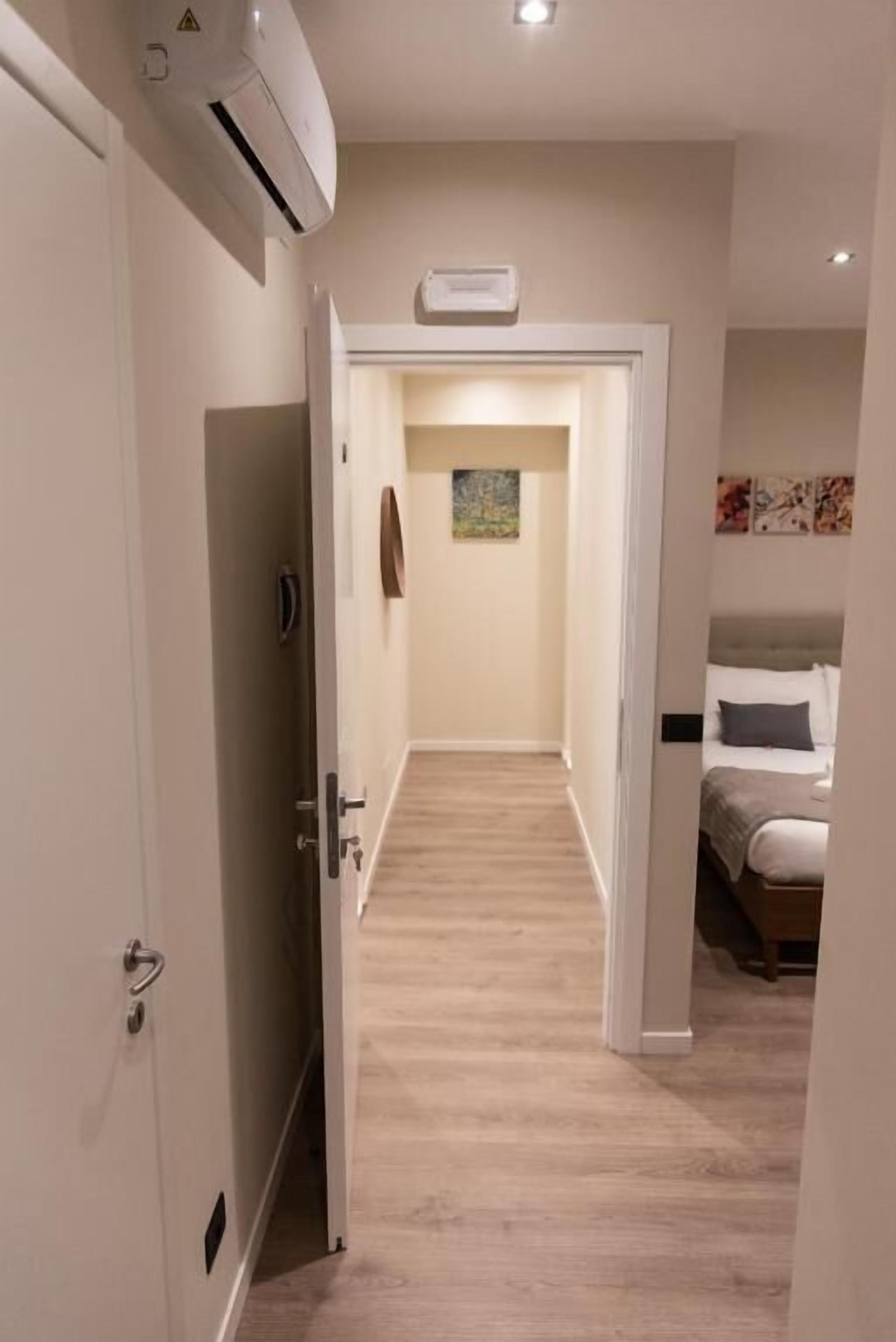 Habitación de hotel con cama, mesita de noche y aire acondicionado de pared.