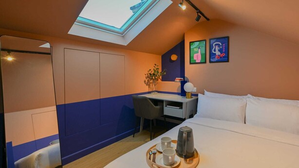 A modern bedroom with a skylight, a bed, a desk, and a tray with cups and a kettle. - Modern Loft En-Suite Room in Angel | Walk to Tube (London)