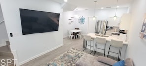 A modern kitchen with a large island, white cabinetry, and pendant lighting. - Villas De Laguna 2 3 Bedroom Townhouse (South Padre Island)