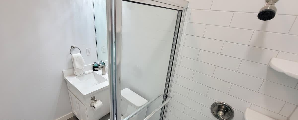 Ein Badezimmer mit Duschkabine, Waschbecken und Toilette.