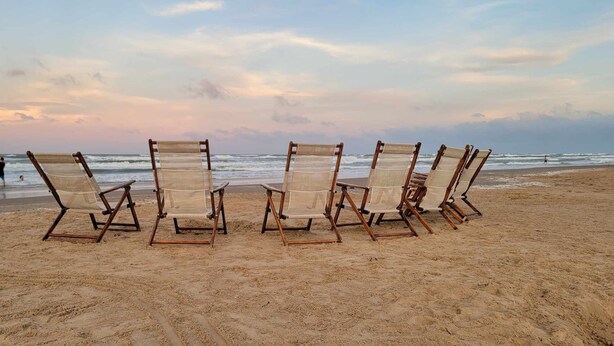A row of beach chairs on a sandy beach with the ocean in the background. - Villas De Laguna 3 3 Bedroom Townhouse (South Padre Island)