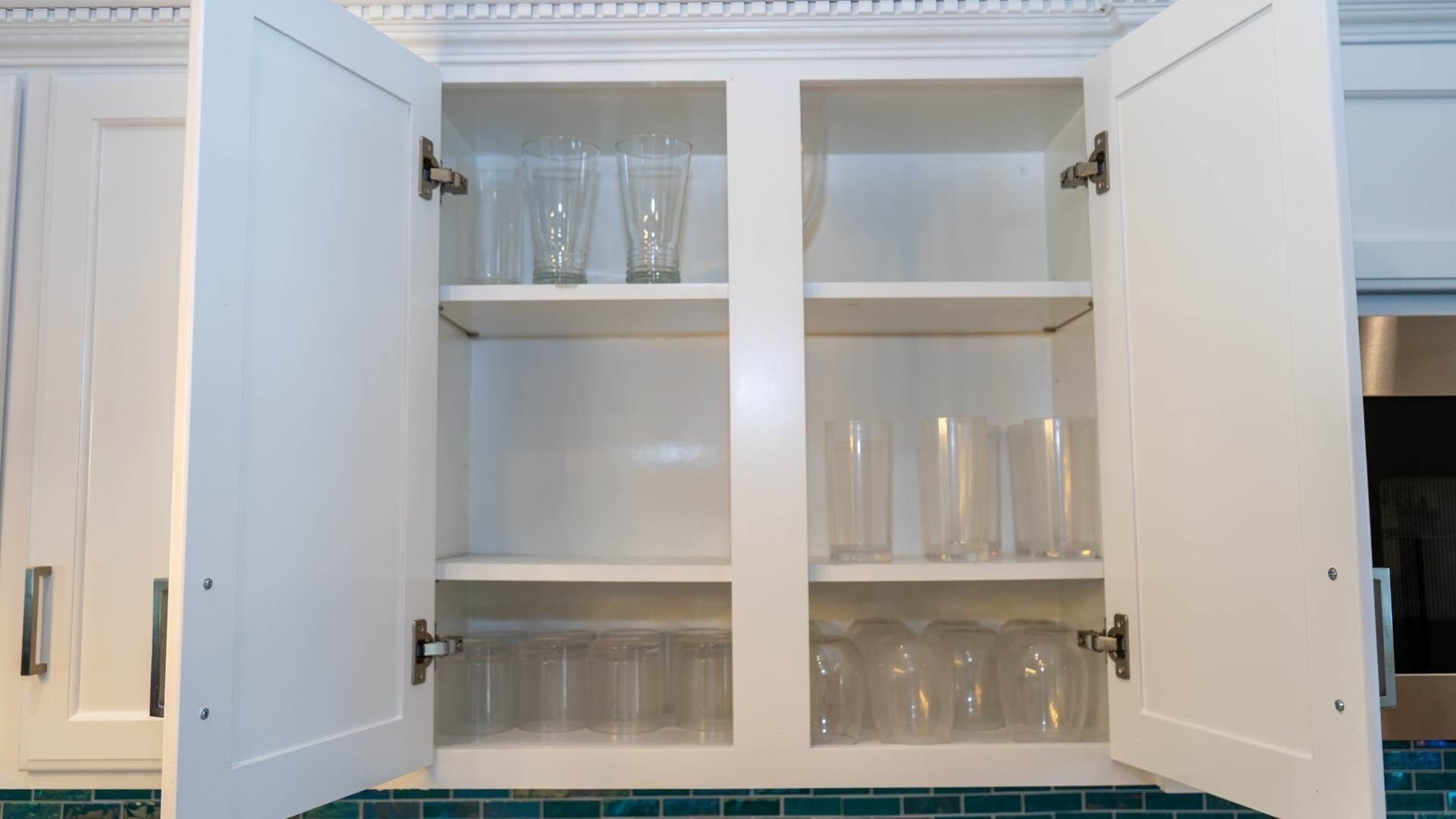 A white cabinet with three shelves, each containing clear plastic containers.