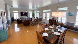 A spacious living room with a dining area set for six.