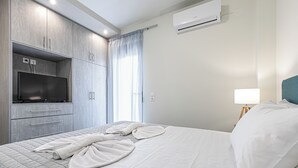 A modern hotel room with a bed, a TV, a wardrobe, and an air conditioner.