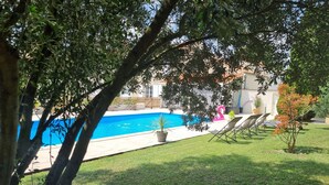 A backyard with a swimming pool, a grassy lawn, and a wooden fence. - Le gite d'URYA - Ideal for a romantic vacation (Saint-Mard)