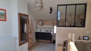 A bedroom with a bed, a wooden ladder, a bathroom with a mirror, sink, and a window. - Le gite d'URYA - Ideal for a romantic vacation (Saint-Mard)
