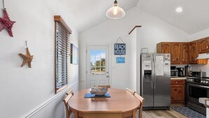 Una cocina funcional con armarios de madera, un refrigerador de acero inoxidable y un microondas.