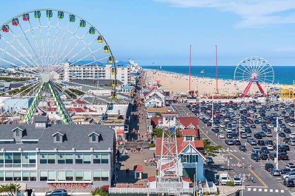 A coastal town with a large Ferris wheel, a beach, and a busy street. - Sea Witch North 303 Steps to the Beach (Ocean City)