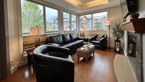 Un salon moderne avec un canapé, une table basse et une cheminée.