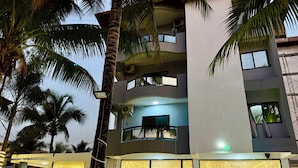A multi-story building with balconies, large windows with curtains, and palm trees. - Setifana Sea view  (Conakry)