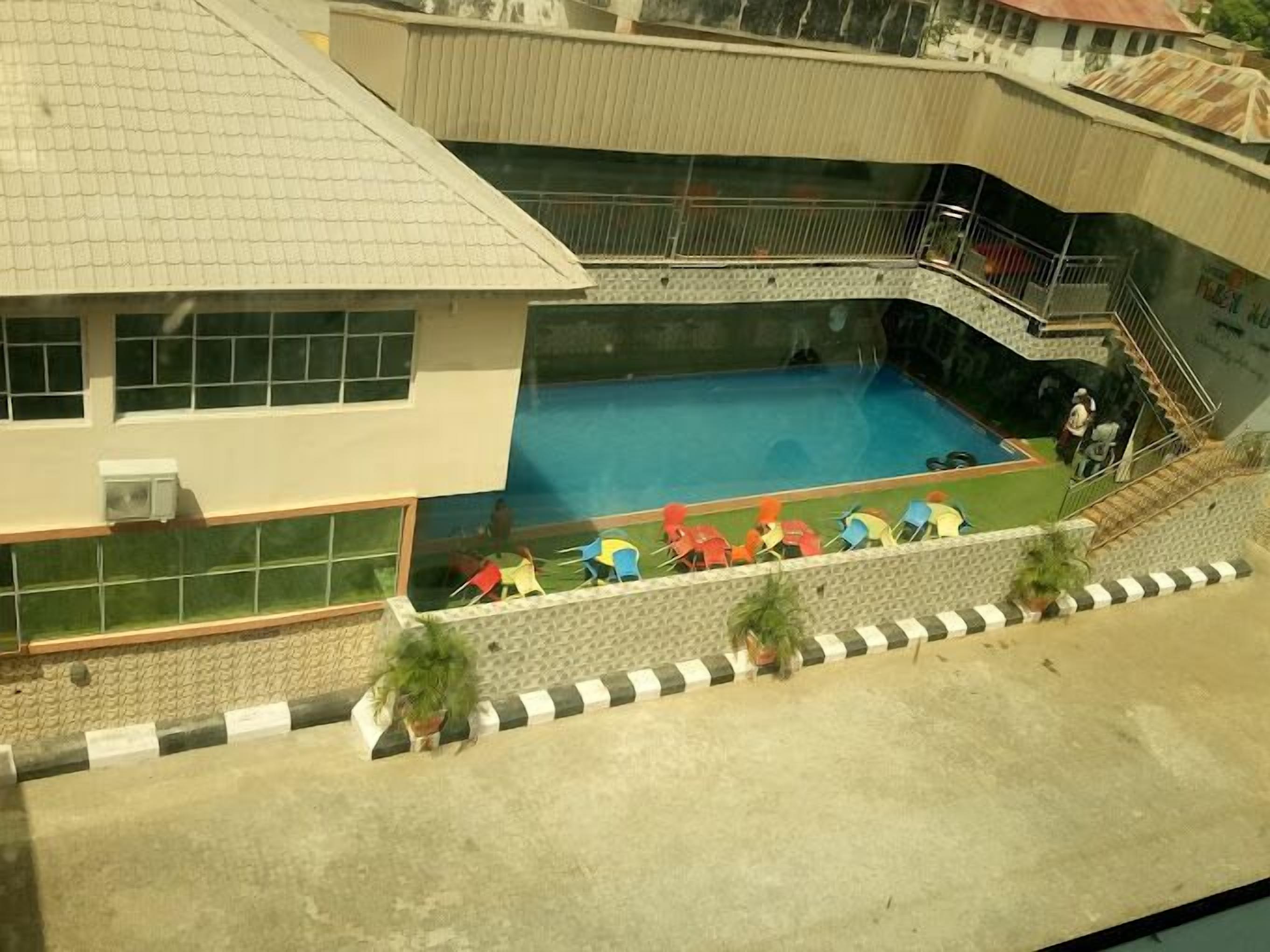 Un edificio con piscina, zona cubierta y escalera.