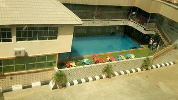 Un edificio con piscina, zona cubierta y escalera.