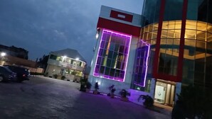 A modern building with a large glass facade and a red and white checkered pattern on the upper right. - Somewatt Fresh Hotel (Ilorin)