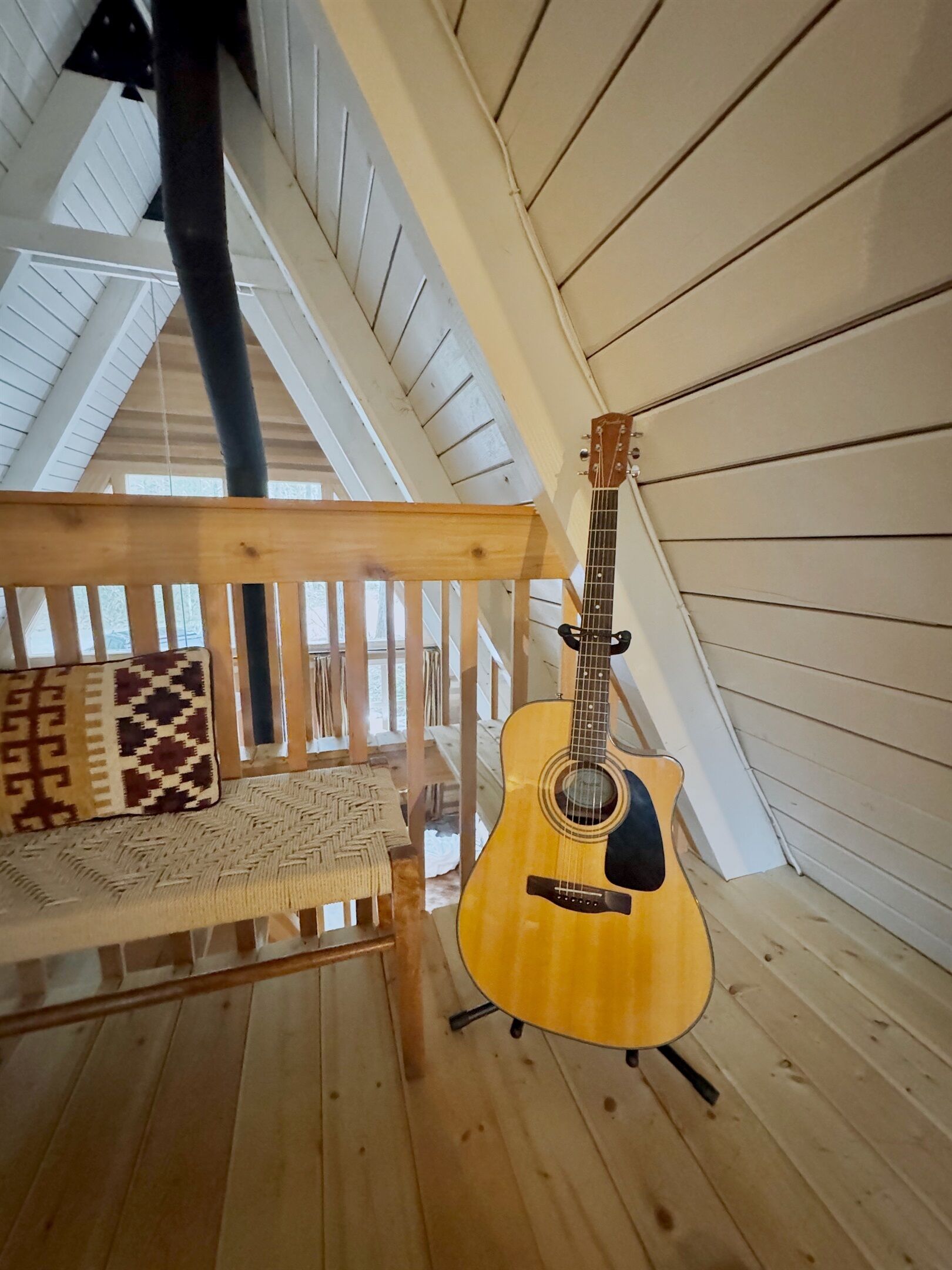 Eine hölzerne Veranda mit einer Bank und einer Gitarre.
