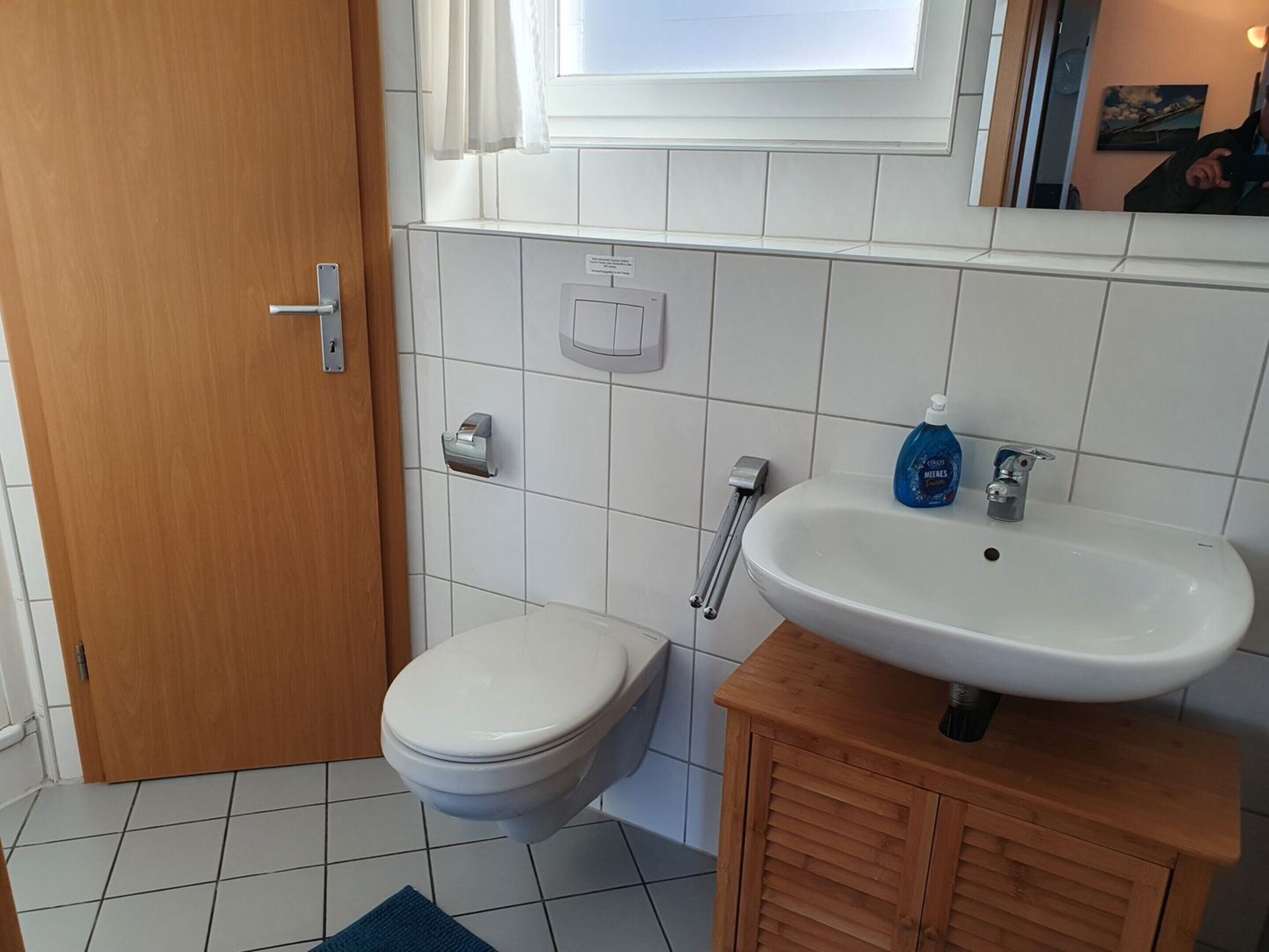Une salle de bain équipée de toilettes, d’un lavabo et d’un sèche-mains.