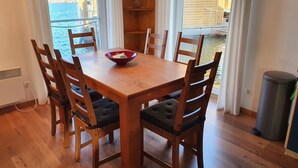 Une table à manger en bois, avec six chaises, un saladier et une suspension.