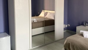 Un dormitori amb llit, armari i tauleta de nit.