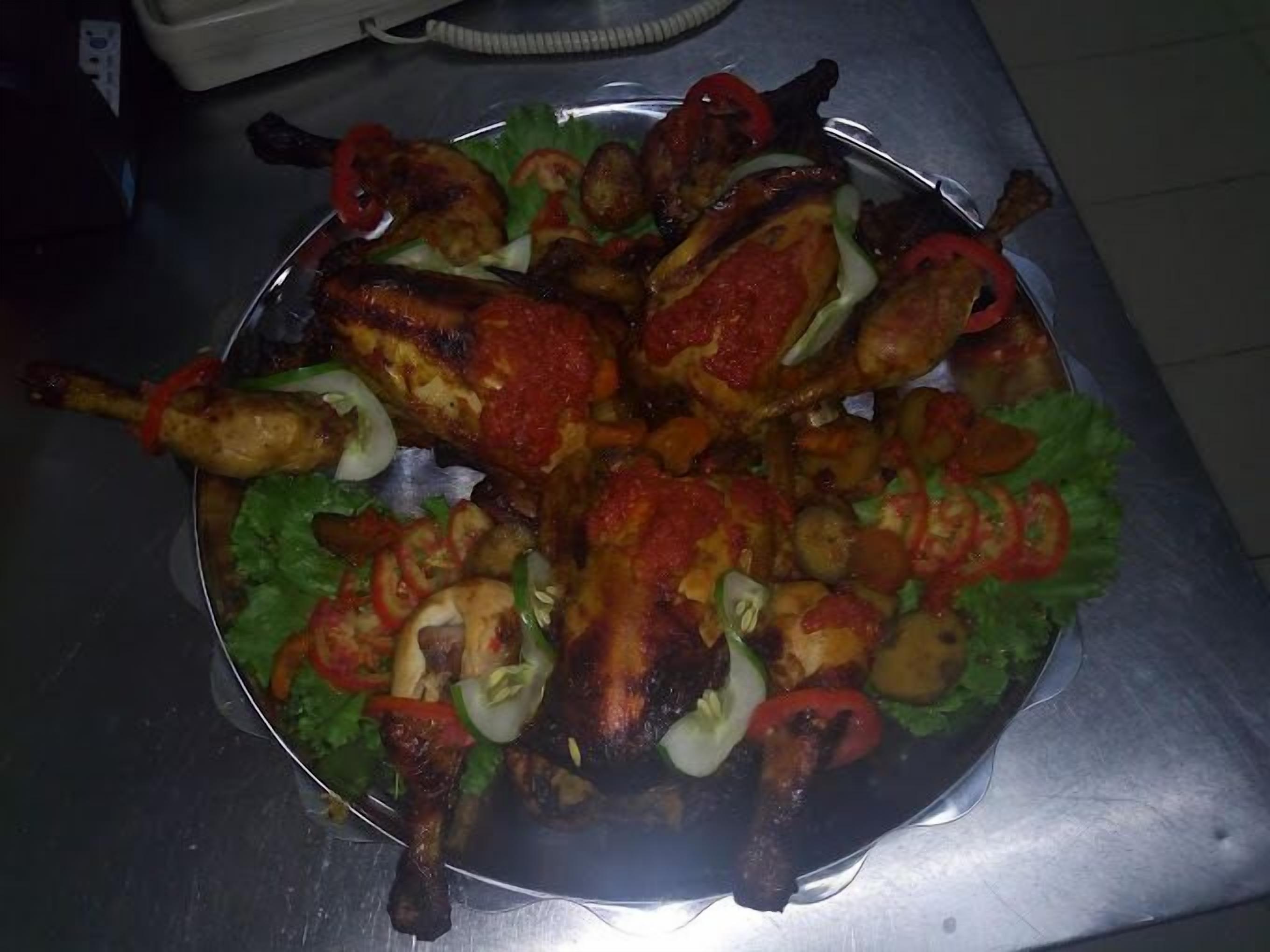 Un plateau en métal contenant du poulet rôti et des légumes.