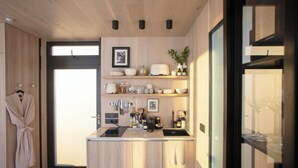 Une cuisine moderne avec des meubles en bois, un four encastré et un plan de travail équipé de divers appareils et ustensiles.