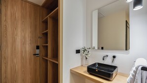 A bathroom with a wooden vanity, a black sink, a mirror, and a towel rack. - LIN Boutique Hotel by HOUSY HOST (Medellín)