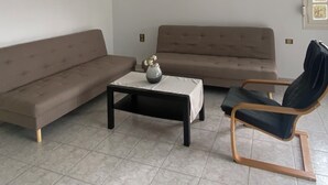 A living room with a sofa, a coffee table, and a chair.