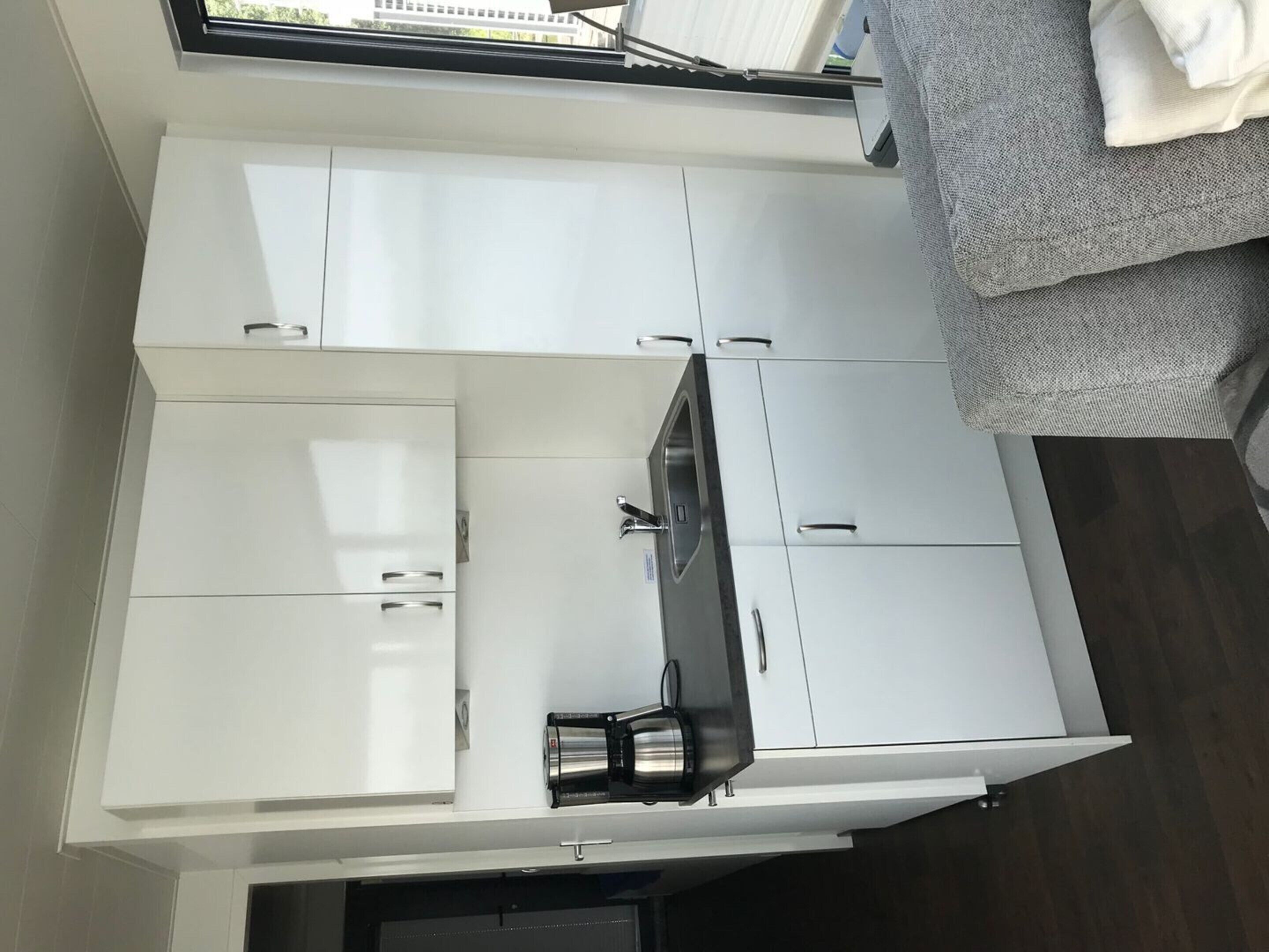 A compact kitchen with white cabinets, a built-in stove, and a small countertop.