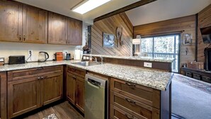 A modern kitchen with wooden cabinets, granite countertops, and a dishwasher.