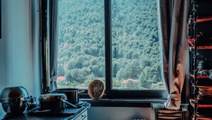 A kitchen with a view of a forest through a window. - K10 Lodge (Curacautin)