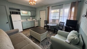 A compact living space with a kitchenette, a dining area, and a seating area.