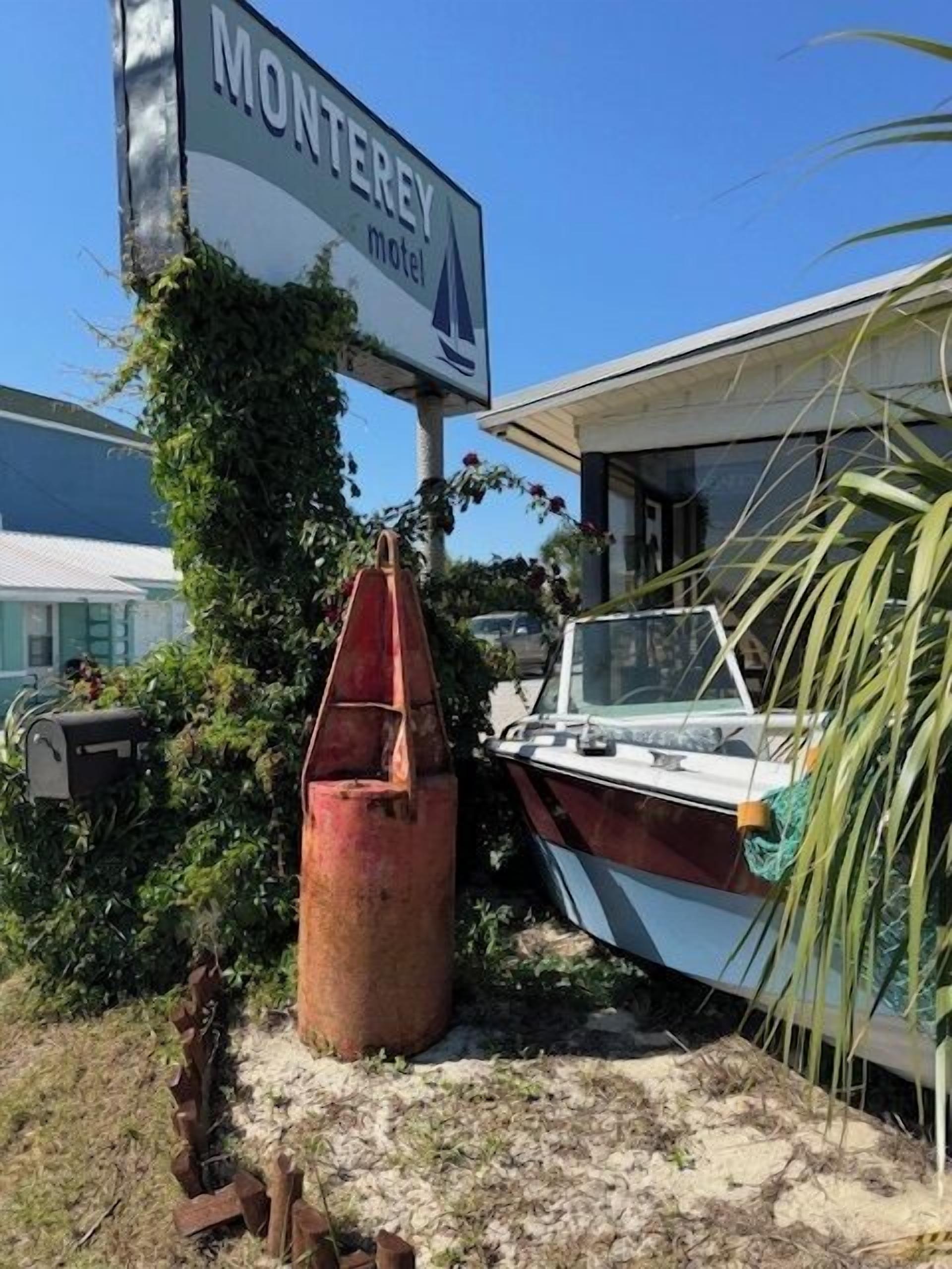 Une enseigne de motel avec un bateau et une ancre rouillée au premier plan.