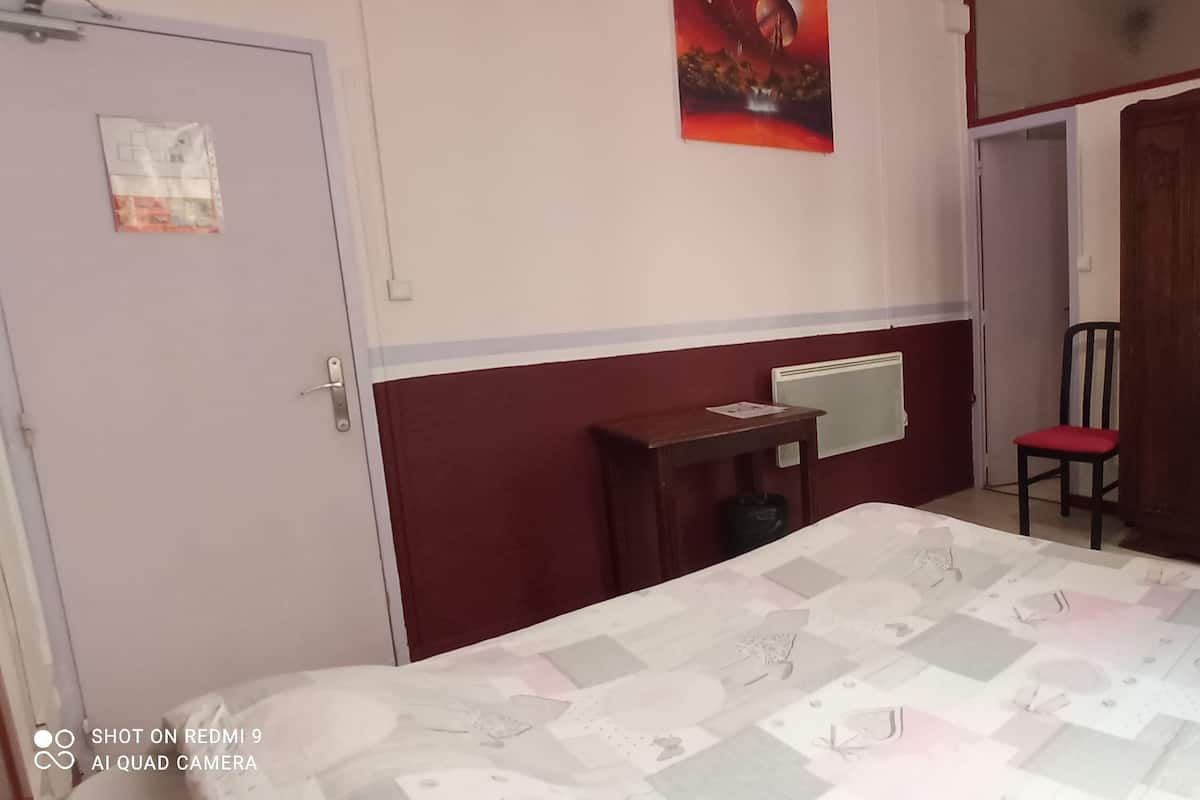 Une chambre à coucher avec un lit, un bureau, une chaise et une armoire.