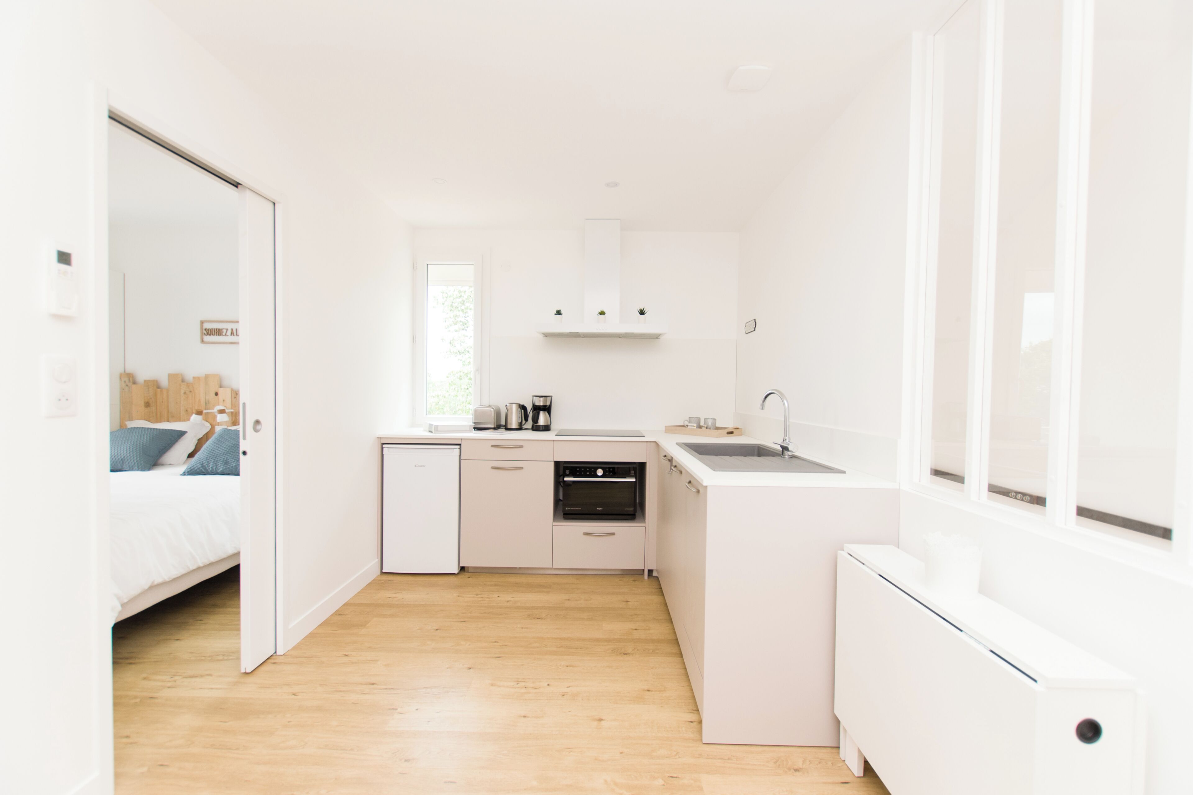 A compact kitchen with white cabinetry, a built-in oven, and a small sink.