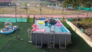 A swimming pool with inflatable toys and a ladder. - RASS Resort (Karjat)