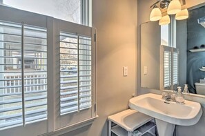 A bathroom with a large window, a sink, and a mirror. - Cozy Downtown Escape (Indianapolis)