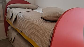 A bunk bed with a red headboard and beige bedding.