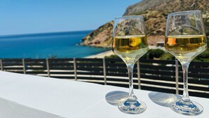 Two wine glasses on a white table with a coastal view. - Villa Yimaré / NEW 2024 Luxury villa / Private pool / Breathtaking sea views (Paralia Fodele)