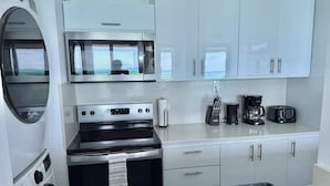 A modern kitchen with a built-in oven, microwave, and a coffee maker.