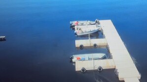 A dock with boats and a small boat on the water.