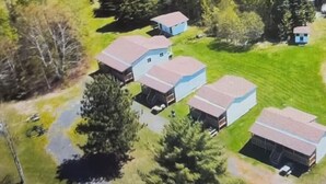 An aerial view of a residential area with multiple houses, each with a distinct roof color and varying sizes.