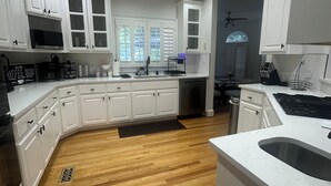A modern kitchen with white cabinetry, a wooden floor, and recessed ceiling lights. - STAR MANSION ATLANTA (Atlanta)