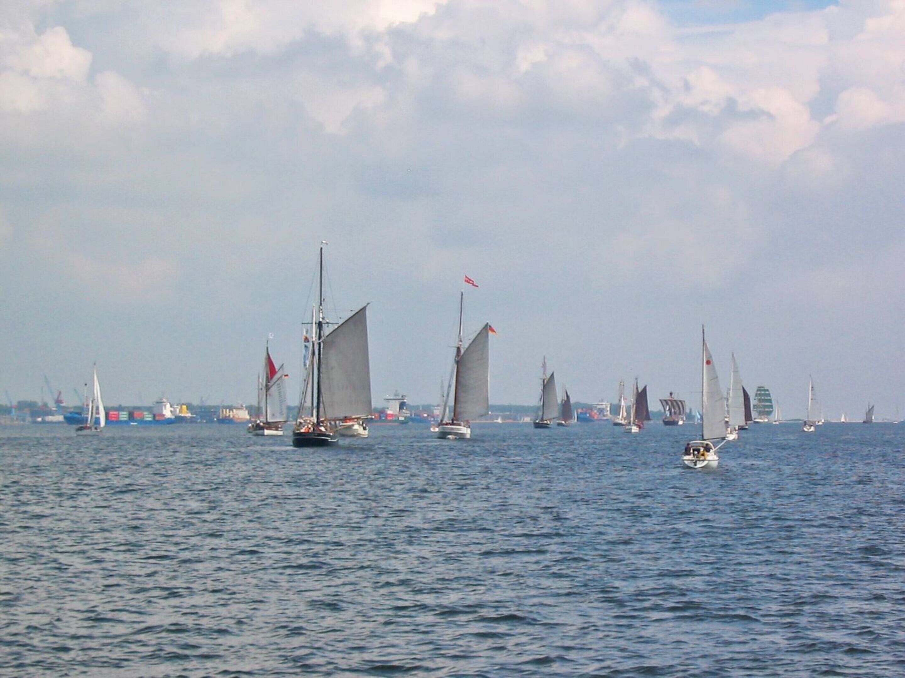 A marina with sailboats and yachts on calm waters.