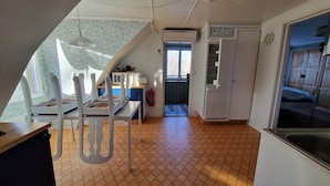 A kitchen with a tiled floor, white cabinets, a microwave, and a sink. - Vacation apartment Fagerhult (Kalmar län)