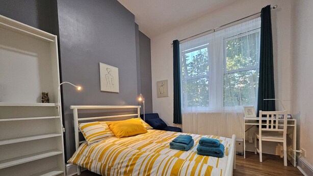 A bedroom with a bed, a desk, and a chair. - Modern Spacious Flat 10 Minutes from Big Ben (London)